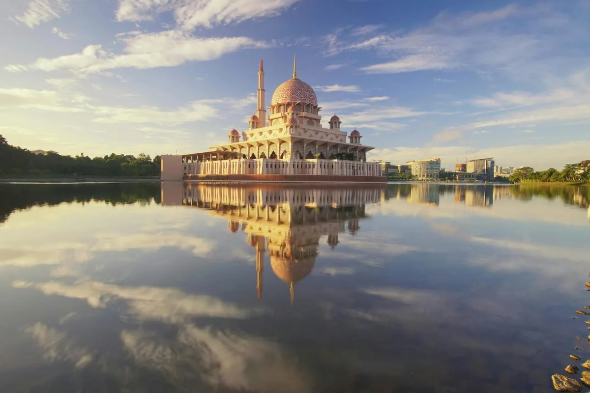 Un bateau de croisière traditionnel Perahu sur le lac de Putrajaya avec la mosquée Putra en arrière-plan